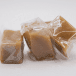 Individually wrapped caramel on a white background.
