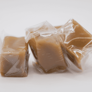 Individually wrapped caramel on a white background.